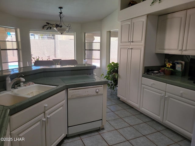 kitchen featuring white dishwasher, tile counters, and white cabinetry