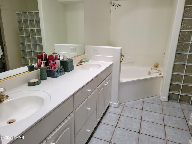 full bathroom featuring a garden tub, double vanity, a sink, and tile patterned floors