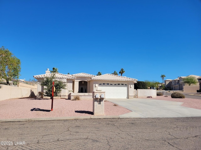 view of front of house featuring stucco siding, an attached garage, fence, driveway, and a tiled roof