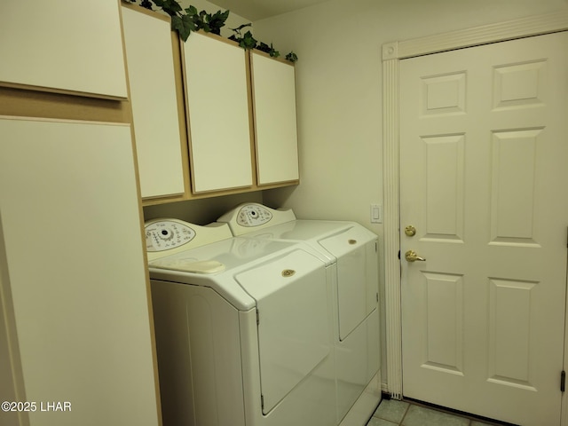 laundry room with washing machine and dryer, cabinet space, and light tile patterned flooring