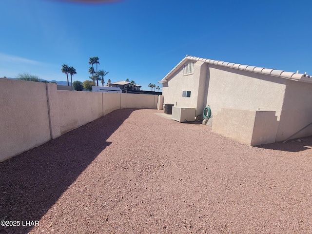 view of yard with a patio area, a fenced backyard, and cooling unit