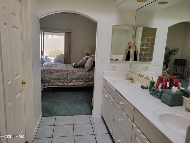 full bathroom featuring double vanity, tile patterned floors, a sink, and ensuite bathroom