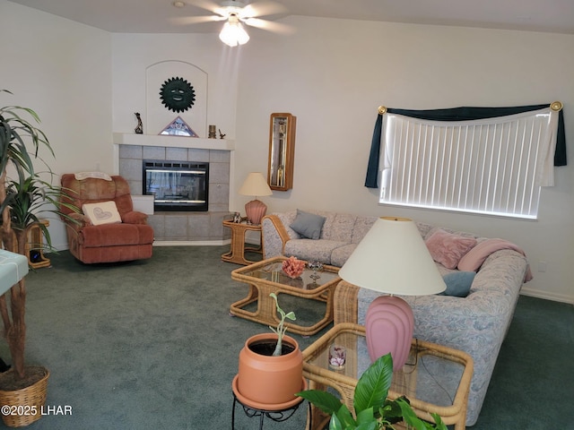 living area featuring a ceiling fan, baseboards, carpet flooring, and a tile fireplace