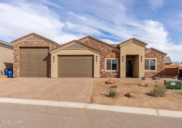 4718 N Banyan Ct, Lake Havasu City, AZ 86404 - view of front of house with decorative driveway, an attached garage, stone siding, and stucco siding