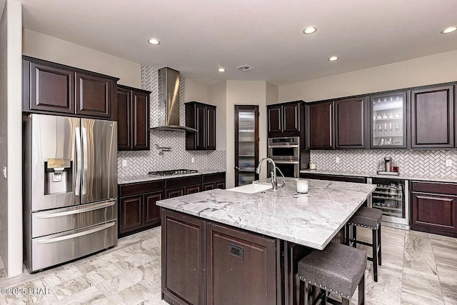 4718 N Banyan Ct, Lake Havasu City, AZ 86404 - kitchen featuring wine cooler, wall chimney exhaust hood, a breakfast bar, appliances with stainless steel finishes, and visible vents