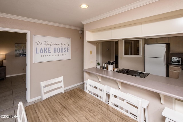 777 Harrah Way Unit 512, Lake Havasu City, AZ 86403 - kitchen featuring tile patterned flooring, freestanding refrigerator, crown molding, a breakfast bar, and stovetop