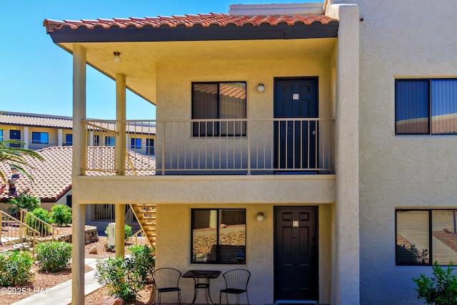 exterior space with stucco siding and stairway