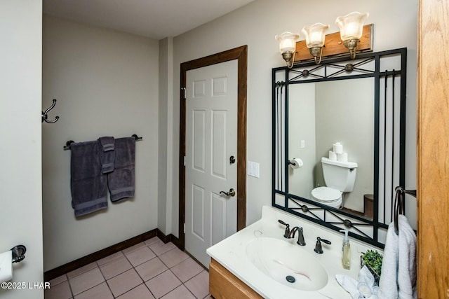 half bathroom featuring toilet, tile patterned flooring, baseboards, and vanity