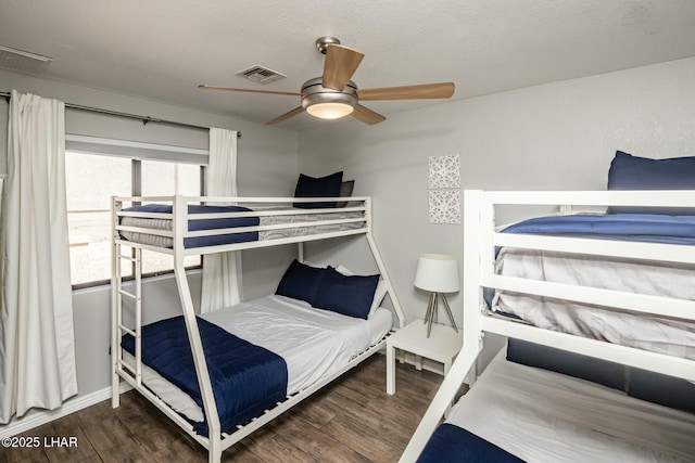 bedroom with ceiling fan, wood finished floors, visible vents, and baseboards