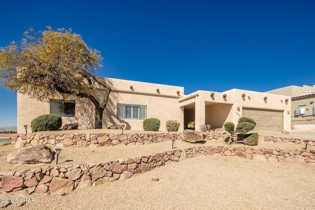 southwest-style home with a garage and stucco siding