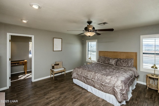 bedroom featuring a ceiling fan, baseboards, visible vents, and wood finished floors