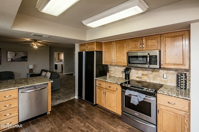 kitchen featuring a raised ceiling, visible vents, appliances with stainless steel finishes, dark wood-type flooring, and open floor plan