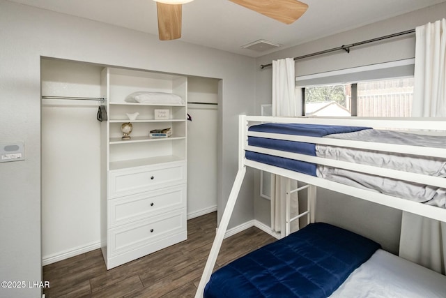 bedroom with dark wood-style floors, ceiling fan, visible vents, and baseboards