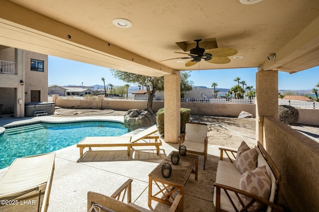 view of pool with a patio, a fenced backyard, a ceiling fan, and a hot tub