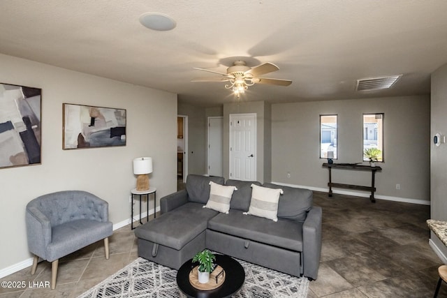 living room with ceiling fan, visible vents, and baseboards