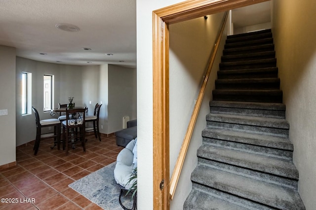 stairway with tile patterned flooring and baseboards