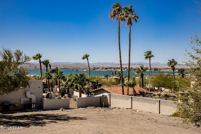 property view of water featuring a gate, fence, and a mountain view