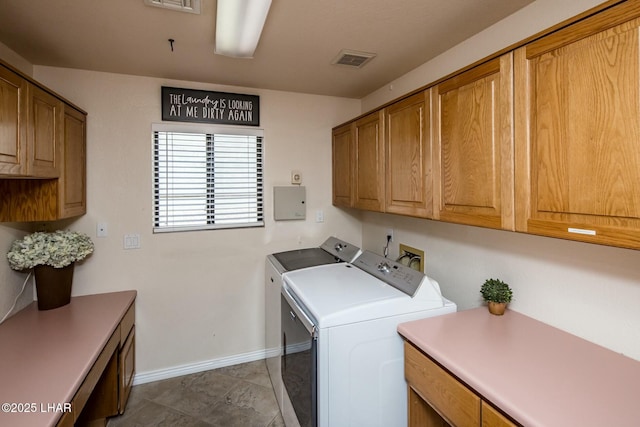 clothes washing area featuring washing machine and clothes dryer, cabinet space, visible vents, electric panel, and baseboards