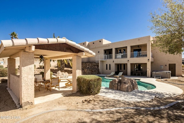 pool with a patio area, a ceiling fan, and a hot tub