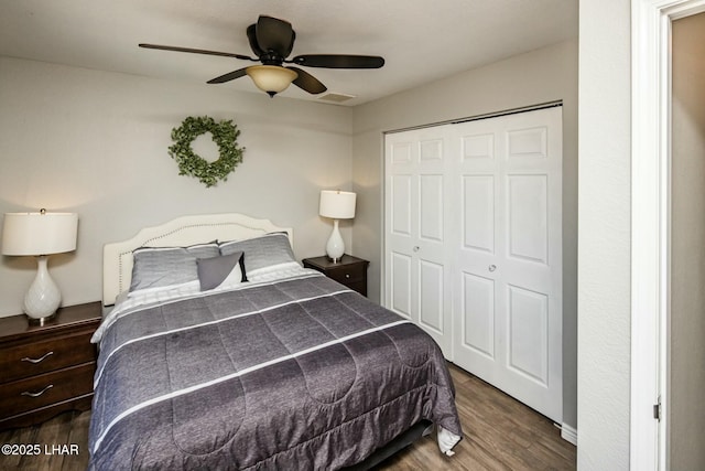 bedroom featuring visible vents, a closet, wood finished floors, and a ceiling fan