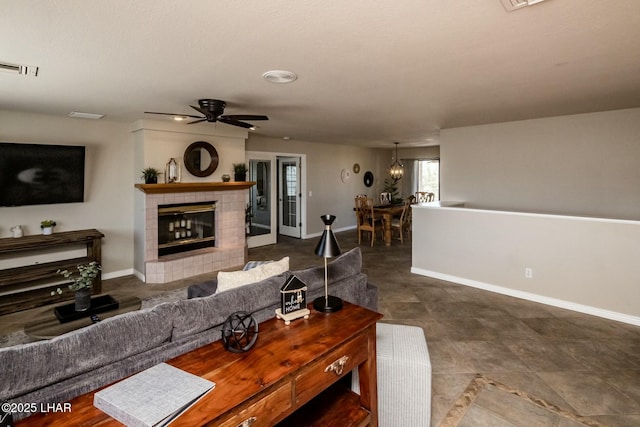 living area featuring visible vents, a fireplace, baseboards, and ceiling fan