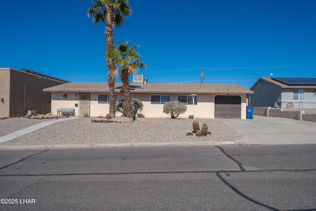 single story home with a garage, concrete driveway, and stucco siding