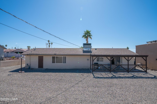 rear view of house with a patio, central AC unit, and fence