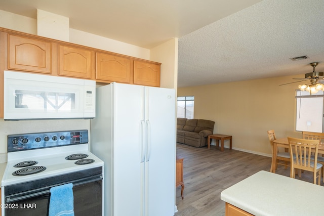 kitchen featuring white appliances, visible vents, a textured ceiling, and light wood finished floors