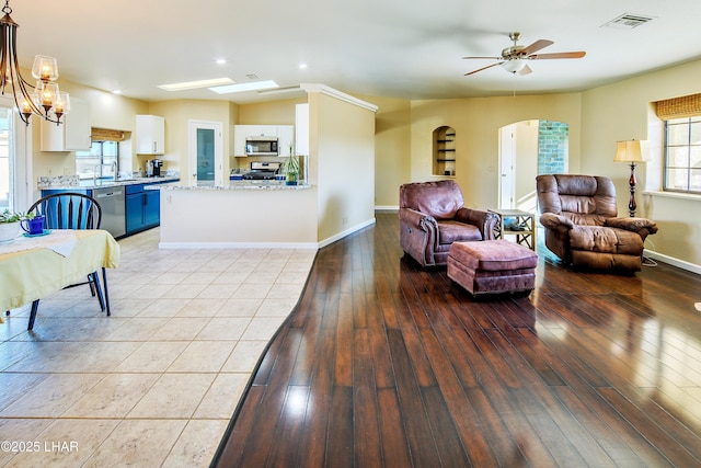 living room with sink, ceiling fan with notable chandelier, and light wood-type flooring