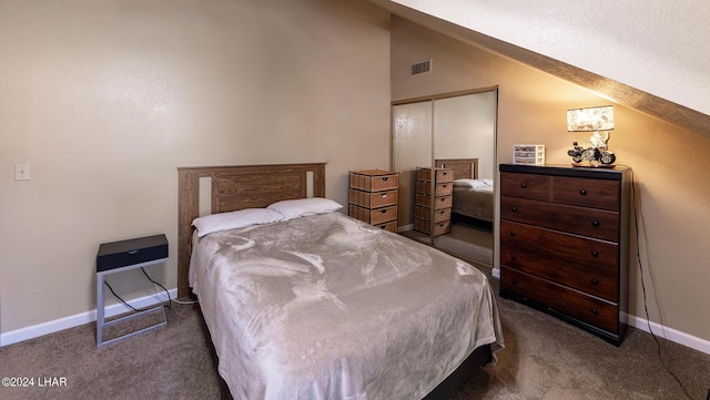 bedroom featuring lofted ceiling, a closet, and dark colored carpet