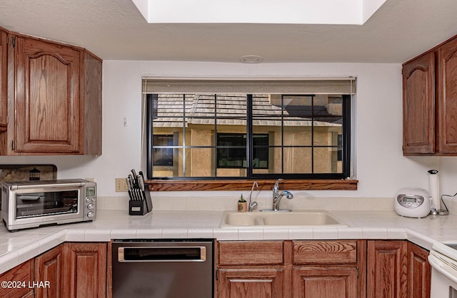 kitchen with sink, tile counters, white electric stove, and dishwasher