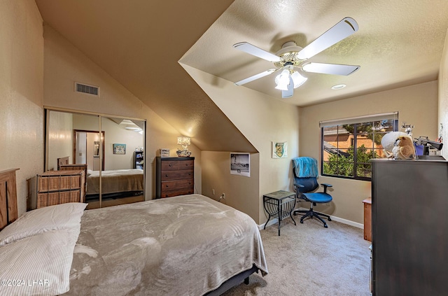 carpeted bedroom featuring ceiling fan, lofted ceiling, and a textured ceiling