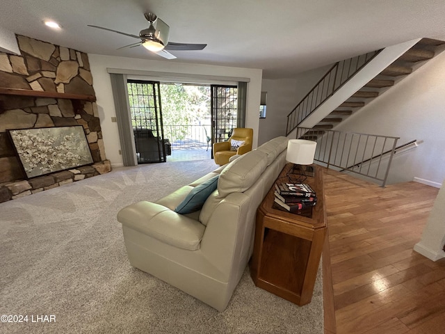 living room with wood-type flooring, a fireplace, and ceiling fan