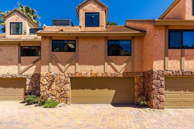 view of front of house with cooling unit and a garage