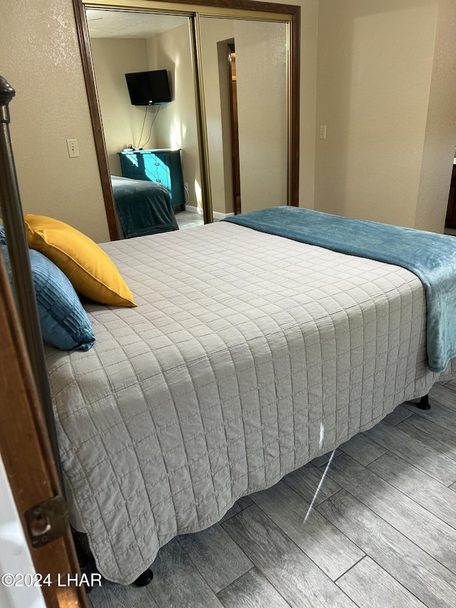 bedroom with hardwood / wood-style floors and a closet