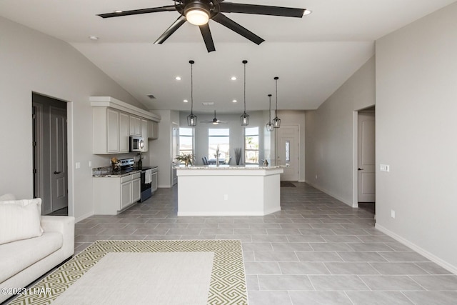 kitchen featuring light stone counters, decorative light fixtures, appliances with stainless steel finishes, a kitchen island, and ceiling fan