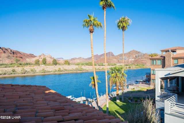 property view of water with a mountain view and a dock