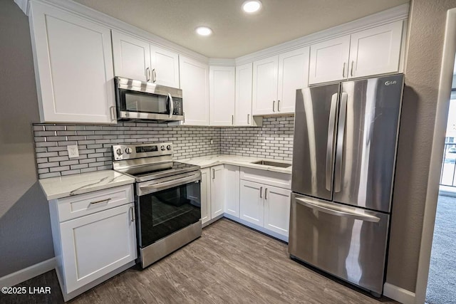 276 Lake Havasu Ave S Unit C31, Lake Havasu City, AZ 86403 - kitchen featuring appliances with stainless steel finishes, white cabinets, tasteful backsplash, wood finished floors, and recessed lighting