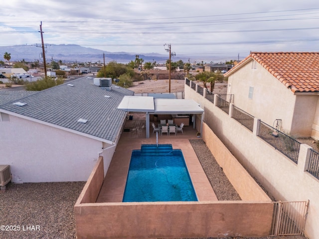 view of pool with a fenced in pool, central AC, a fenced backyard, a patio area, and a mountain view