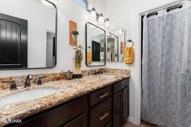 bathroom featuring curtained shower, double vanity, and a sink