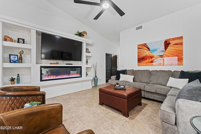 living area with visible vents, built in shelves, ceiling fan, vaulted ceiling, and a glass covered fireplace