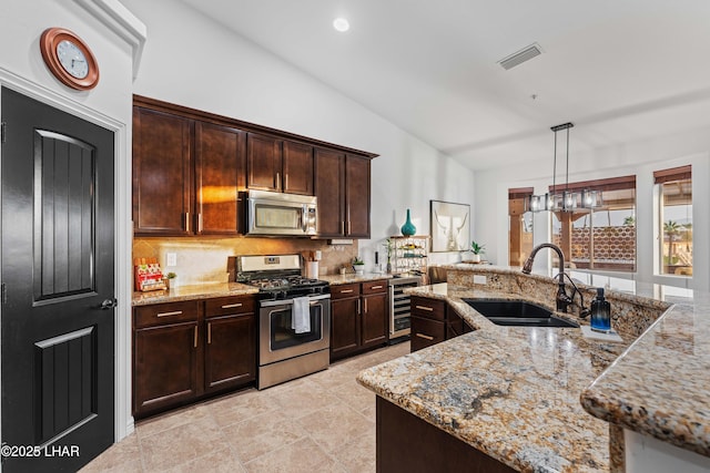 kitchen featuring visible vents, beverage cooler, a sink, stainless steel appliances, and lofted ceiling