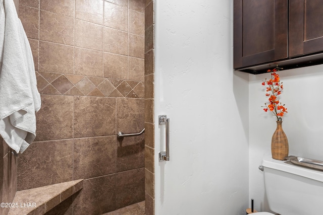 bathroom featuring toilet and tiled shower