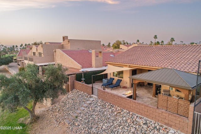 back of property at dusk featuring stucco siding and a patio