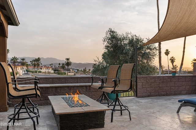 patio terrace at dusk with a mountain view and an outdoor fire pit