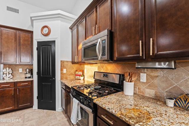 kitchen featuring visible vents, tasteful backsplash, stainless steel appliances, dark brown cabinetry, and light stone countertops