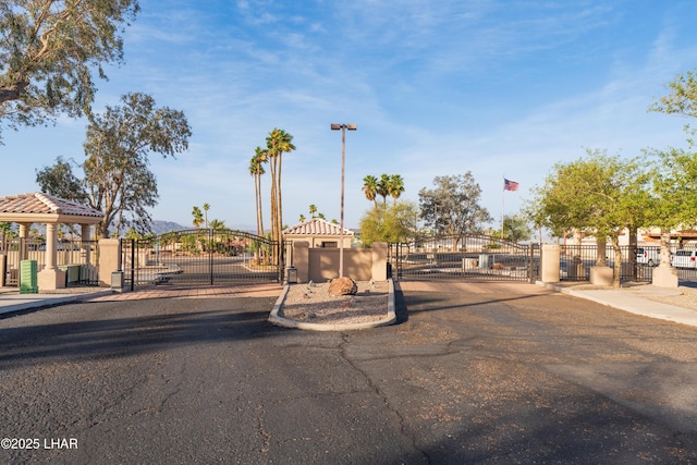 exterior space with a gate, curbs, and a gated entry