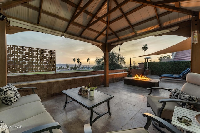 patio terrace at dusk featuring an outdoor living space with a fire pit and a gazebo