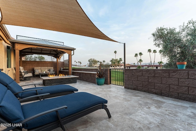 view of patio / terrace featuring an outdoor living space with a fire pit, a gazebo, a gate, and fence