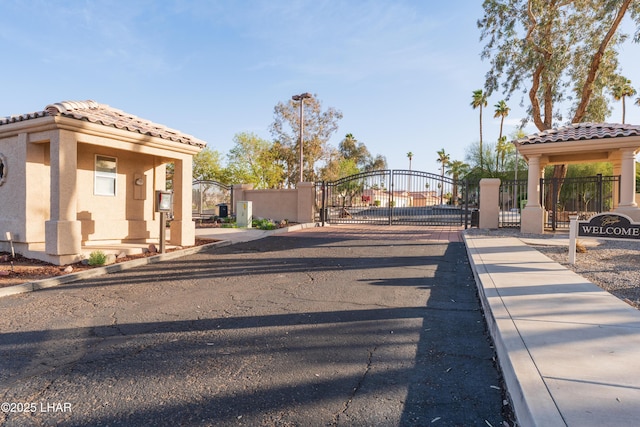 view of street featuring curbs, a gated entry, and a gate